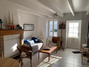 a living room with a couch and a fireplace at Petite Maison de Pêcheur in Mesquer