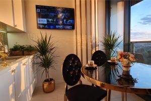 a kitchen with a table and chairs and a tv at Diamond class 2 Hanza Tower in Szczecin