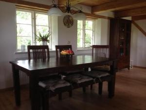 NorderfriedrichskoogReetdachhaus Für Erholsamen Familienurlaub的餐桌、椅子和墙上的时钟