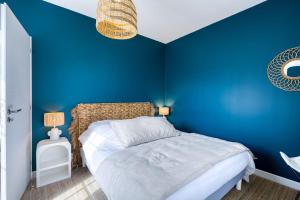 Un dormitorio azul con una cama y una pared azul. en Maison des Bouillats - Welkeys, en Saint-Trojan-les-Bains