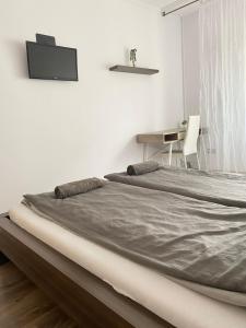 a bed in a white room with a desk at City Center in Szeged