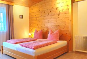 a bedroom with a bed with a wooden wall at Neubauhof in Reith im Alpbachtal