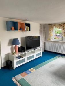a living room with a television and a white entertainment center at Siegmund in Waltershausen