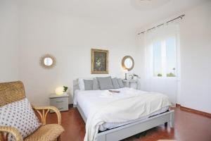 a white bedroom with a bed and a chair at Casa Storica a San Terenzo in San Terenzo