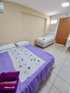 a room with a bed with purple sheets and flowers on it at #Flats Studio 45 Bueno Oeste in Goiânia