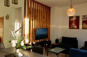 a living room with a couch and a table and a tv at Paddington House - private pool & rooftop in Flic-en-Flac