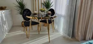 a glass table with two black chairs and a table with flowers at Diamond class 2 Hanza Tower in Szczecin