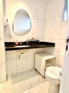 bagno bianco con servizi igienici e specchio di Apartamento com piscina Praia de Iracema, Aquarius Residence-Fortaleza a Fortaleza