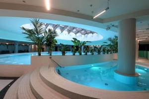 a large swimming pool in a building with a large tub at Diamond class 2 Hanza Tower in Szczecin