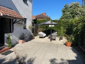 a patio with an umbrella and two chairs at Camaraderie Guest House in York