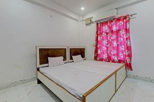 a bed in a room with a red curtain at Hotel O ONCE MORE RESTAURANT AND CAFE in Prayagraj