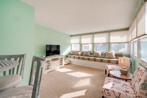a living room with a couch and a tv at 1 Block to Brigantine Beach Breezy Home with Patio! in Brigantine