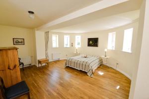 a bedroom with a bed and wooden floors and windows at Wohnung Im Erdgeschoss Des Gutshauses in Neuenkirchen
