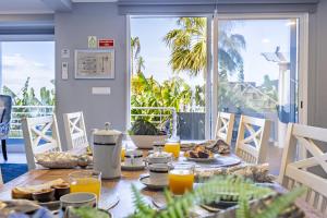 a table with breakfast food and orange juice on a balcony at Casa da Fonte by YOUR KEY - 1st floor house in Ribeira Brava