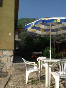 una mesa, dos sillas y una sombrilla en Ferienhaus In Salò Mit Grill, Terrasse Und Garten, en Saló