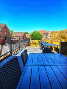a patio with a blue table and chairs and a fence at The Buxted Inn in Buxted
