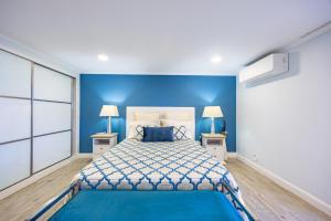 a blue bedroom with a bed and two lamps at Casa da Fonte by YOUR KEY - 1st floor house in Ribeira Brava