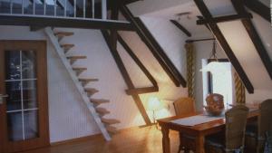 a living room with a dining room table and a staircase at Ferienwohnung In Volksdorf Mit Großer Terrasse in Meerbeck