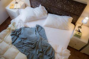 un letto con lenzuola e cuscini bianchi in una camera da letto di Casa Della Musica a Ostra