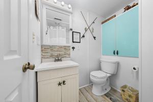 a white bathroom with a toilet and a sink at The Iron Seahorse Orlop Surf City Condo in Surf City +52 photos