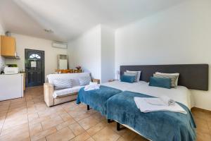 a bedroom with a large bed and a couch at Montinhos Nature Stay in Luz +53 photos