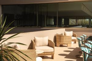 a group of chairs sitting on a patio at Kimpton Atlantico Algarve by IHG in Albufeira