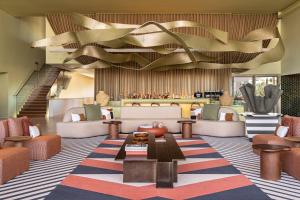a lobby with couches and a table and a staircase at Kimpton Atlantico Algarve by IHG in Albufeira