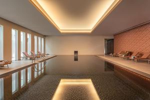 an empty pool in a room with chairs at Kimpton Atlantico Algarve by IHG in Albufeira