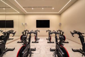 a row of exercise bikes in a room with a flat screen tv at Kimpton Atlantico Algarve by IHG in Albufeira