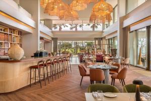 a restaurant with tables and chairs and a bar at Kimpton Atlantico Algarve by IHG in Albufeira