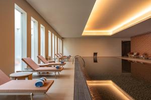 a swimming pool with lounge chairs and a swimming pool at Kimpton Atlantico Algarve by IHG in Albufeira