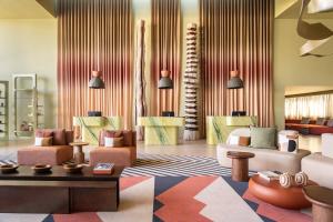 a living room with a couch and chairs and a table at Kimpton Atlantico Algarve by IHG in Albufeira