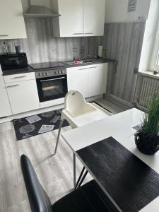 a kitchen with white cabinets and a table and chairs at Ferienwohnung Knobloch Louis in Oberhausen +23 photos