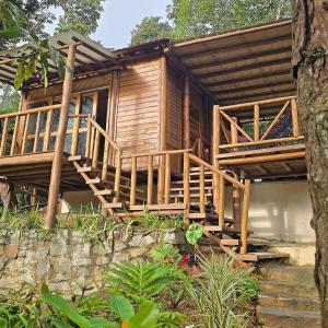 a wooden house with a staircase leading to it at Natural Harmony Bungalow in Baturité
