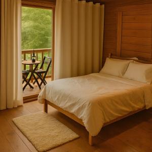 a bedroom with a bed and a balcony with a table at Natural Harmony Bungalow in Baturité +10 photos