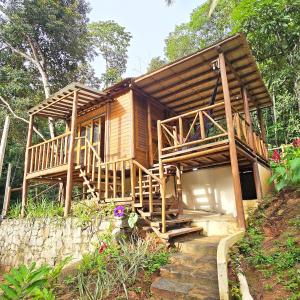 a wooden house with a staircase leading to it at Natural Harmony Bungalow in Baturité
