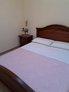 a bedroom with a bed and a vase of flowers at Casaparrinello Maletto Concy in Maletto