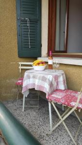 una mesa y sillas con un bol de fruta. en Ferienhaus In Salò Mit Grill, Terrasse Und Garten, en Saló