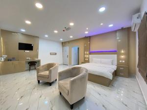 a hotel room with a bed and two chairs at Marina in Sohar