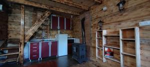 a kitchen in a log cabin with a stove at Vajat 2 - Zlatarsko jezero in Goronjići +7 photos