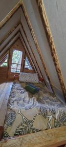 a large bed in a room with a roof at Vajat 2 - Zlatarsko jezero in Goronjići