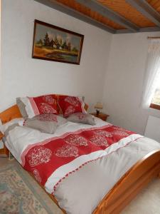 a bedroom with a bed with red and white blankets at Les hauts du Schliffels in Fellering