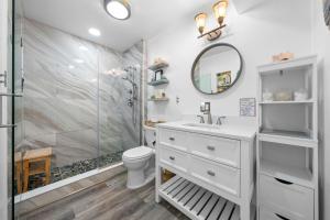 a bathroom with a shower and a sink and a toilet at The Iron Seahorse Surf City Beach Home in Surf City +74 photos