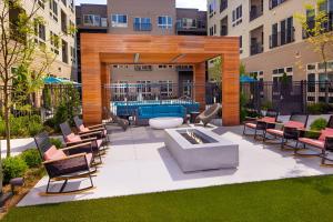 eine Terrasse mit Stühlen und einem Pool in einem Gebäude in der Unterkunft Well-Appointed Stay - Gym, Lounge & Modern Comfort in Alexandria