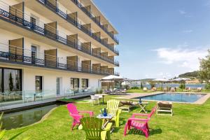 a hotel with colorful chairs and a pool at Golden Tulip Hotel & Rooftop Martigues Provence in Martigues