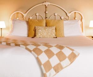 a bedroom with a bed with yellow and white pillows at Albert's in Shelburne