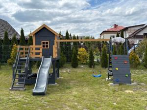 a playground with a slide and a play structure at Pod Roztoczańskim Niebem in Wólka Wieprzecka