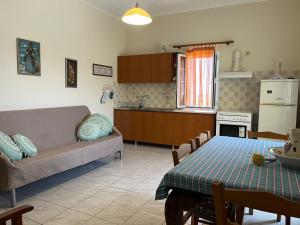 a kitchen and a living room with a table and a couch at Drymonas cottage in Kythira