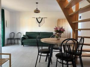 a living room with a green couch and a table and chairs at Pod Roztoczańskim Niebem in Wólka Wieprzecka +13 photos