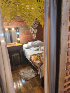a small bedroom with a bed and a mirror at Pousada Tarumã challes 3 in Bonito